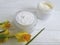Cream facial cosmetic extract above care rustic organic daffodil on white wooden treatment