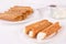Cream filled brandy snaps and unfilled snaps and a pot with cream