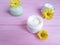 Cream jar cosmetic care wellness product handmadeyellow chamomile flowers pink wood background