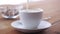 Cream pouring to coffee cup on wooden table