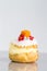 Cream puff cakes or profiterole filled with whipped cream served with fruit and decoration and icing flower