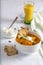 Cream of pumpkin soup with dollop of sour cream and crackers isolated on white blanket. In the background a glass of