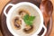 Cream soup in a white plate. Mushroom soup. Potato soup with mushrooms. Top view, wooden background