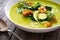 Cream zucchini soup with croutons, Parmesan cheese and fresh dill on wooden table