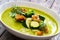 Cream zucchini soup with croutons, Parmesan cheese and fresh dill on wooden table