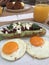 Creamy avocado on sourdough bread topped with pomegranate seeds and crumbled feta cheese served with two medium fried eggs