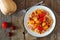 Creamy butternut squash pasta with bacon and tomatoes over wood