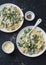 Creamy chicken, green peas, spinach farfalle pasta on a dark background, top view. Mediterranean style