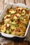 Creamy chicken zucchini casserole with bacon close-up in a baking dish. vertical