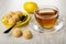 Creamy fudge, spoon in saucer, lemon, transparent cup with tea on saucer on wooden table