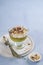 Creamy Green tea matcha dessert, mousse in a glass with hazelnut and burnt meringue on a light blue background with space for text