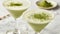 Creamy matcha martini - Matchatini, trendy cold summer cocktail. Matcha cocktails in martini glasses with green matcha powder.