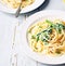 Creamy pasta with spinach and cream cheese on white rustic country wooden table, homemade easy meal recipe for lunch or dinner,