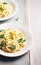 Creamy pasta with spinach and cream cheese on white rustic country wooden table, homemade easy meal recipe for lunch or dinner,