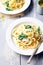 Creamy pasta with spinach and cream cheese on white rustic country wooden table, homemade easy meal recipe for lunch or dinner,