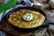 Creamy Potato Gratin in Cast Iron Skillet Topped with Sour Cream and Chives