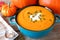 Creamy pumpkin soup in a blue bowl close up