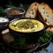 Creamy pumpkin soup with parsley and seeds on a black background