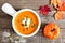 Creamy pumpkin soup on rustic wood background