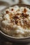 Creamy Rice Pudding Topped with Almonds and Cinnamon in a White Bowl