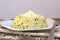 Creamy risotto with cucumber and cheese on white plate with fork on grown cloth on dark wooden background