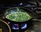 Creamy spinach in a cooking pan on fire at live kitchen