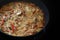 Creamy vegetable ragout with bell pepper, mushroom and onion in a pan on a black stove, copy space