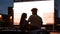 Create memories here. Silhouetted view of attractive young couple, boy and girl spending time together, sitting in the