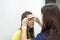 Create permanent eyebrow makeup. Microblading eyebrows work flow in a beauty salon. Cosmetician putting on film on eyebrows.