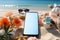 Create your message on a smartphone\\\'s blank screen amidst beach accessories