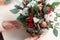 Creating Christmas floral arrangement with carnations, chrysanthemum santini flowers and fir