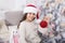 Creating festive atmosphere. Child decorating christmas tree with red ball. Girl kid decorating christmas tree