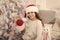 Creating festive atmosphere. Child decorating christmas tree with red ball. Girl kid decorating christmas tree