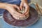 Creating jar or vase of clay. Woman hands, potter`s wheel