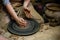 Creating a jar or vase Master crock. The sculptor in workshop makes jug out of earthenware closeup