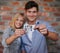 Creating memories. A young couple standing in front of a brick wall holding a photo to the camera.