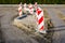 Creation of a new street in the city, frontal view of red and white striped vertical road barriers