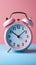 Creative alarm clock on pastel pink-blue backdrop, embodying minimal pastel trend.