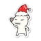 A creative angry polar bear distressed sticker cartoon of a wearing santa hat