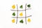 Creative autumn concept. Tic-tac-toe, noughts and crosses between summer and autumn. Green and yellow leaves in grid made from