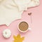 Creative autumn flat lay overhead top view coffee milk latte cup on millennial pink background copy space minimal style. Fall