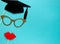 Creative background with photobooth props for graduation: hats, diploma, glasses, lips on bright blue paper background. Education,