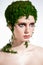 Creative beauty portrait of woman with green moss on her head