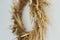 Creative boho wreath with dried pampas grass, wildflowers, wheat,  on white wall. Stylish autumn rustic wreath, details close up.