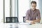 Creative businessman reading file at desk in office