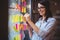 Creative businesswoman sticking adhesive notes to glass in office