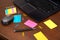 Creative Chaos: Colorful Sticky Notes and Desk Essentials on Wooden Surface