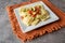 Creative cheese ravioli topped with fresh tomato and avocado and seasoning.