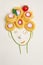 creative children food concept, cute girl`s face made of ripe vegetables and Italian spaghetti pasta with red tomato as hair, fla