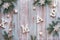 Creative Christmas flat lay with white letters Xmas on rustic wooden boards. Fir twigs decorated with wooden snowflakes and white